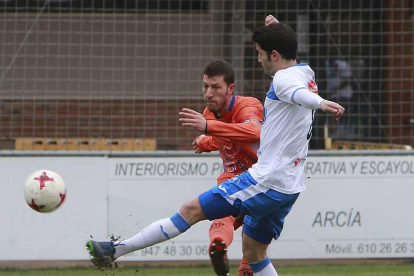 Jairo golpea un balón ante un jugador del Almazán-Raúl G. Ochoa
