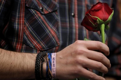 Iglesias sostiene una rosa con la mano en la que luce una pulsera podemista con el lema de Sánchez contra la abstención del PSOE en la investidura de Rajoy.-JOSE LUIS ROCA