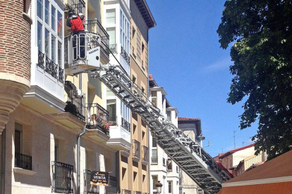 Los bomberos intervienen en un edificio de Fernán González, donde ayer se cayó parte de la fachada.-ISRAEL L. MURILLO
