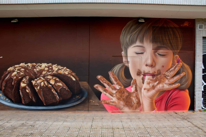 La niña y el pastel de chocolate, protagonistas del mural de arte urbano.