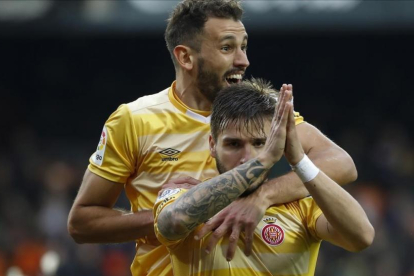 Stuani abraza a Portu, que pide perdón por marcar al Valencia.-/ MIGUEL LORENZO