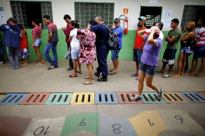 Un grupo de personas forma una fila en un puesto de votación en la favela Estrutural, en Brasilia, durante la segunda vuelta de las elecciones presidenciales.-EFE /Foto: FERNANDO BIZERRA JR.