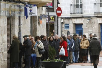 Una larga cola de gente esperando para entrar a la Administración El Gato Negro en la calle Avellanos.-RAÚL G. OCHOA