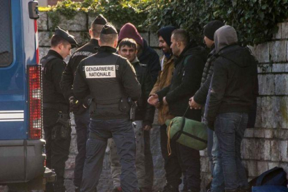 La policía francesa intercepta a un grupo de refugiados que intentan entrar en el Reino Unido por el paso de Calais.-AFP / PHILIPPE HUGUEN