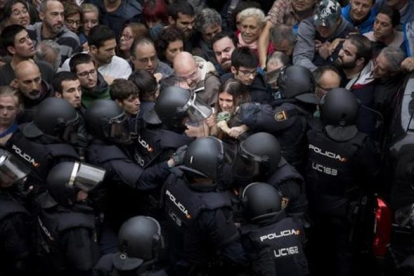 Agentes de la policía nacional intentan desalojar a las personas concentradas en las puertas del colegio Ramon Llull de Barcelona el 1-O.-FERRAN NADEU