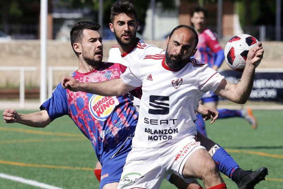Adri pugna por un balón aéreo con un centrocampista de la Gimnástica Segoviana-Raúl G. Ochoa