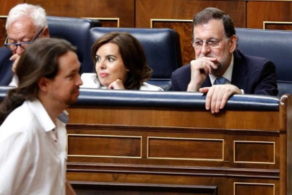 Pablo Iglesias pasa ante Mariano Rajoy mientras se dirige a votar en el acto de constitución de la XII legislatura.-J.M. PRATS