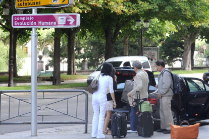 Unos turistas descargan maletas de un vehículo.-ISRAEL L. MURILLO