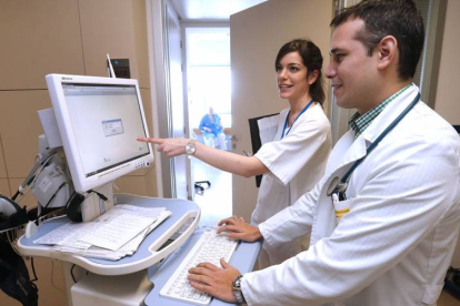 Un médico y una residente utilizan uno de los ordenadores del servicio de Medicina Interna del Hospital Universitario de Burgos-R. OCHOA