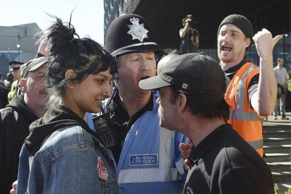 La joven Saffiyah Khan se encara con uno de los meimbros del grupo británico de extrema derecha Liga de Defensa Inglesa (EDL), en su siglas en inglés, en Birmingham el pasado 8 de abril.-AP / JOE GIDDENS