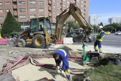 Unos trabajadores tapan el socavón en la Glorieta de Bilbao.-RAÚL G. OCHOA