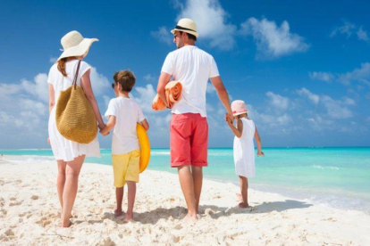 Una familia disfruta de unas vacaciones en una playa paradisiaca.-SHUTTERSTOCK