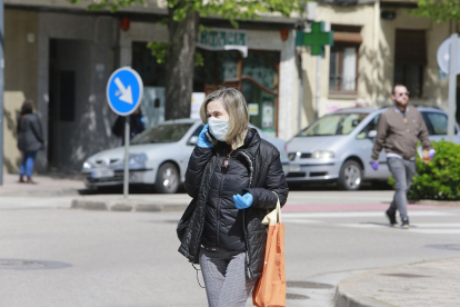 Una mujer con mascarilla y guantes. RAÚL OCHOA