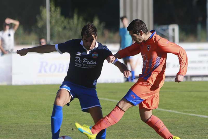 Soto intenta hacerse con un balón ante la presencia de un defensor del Sporting Uxama-Raúl G. Ochoa