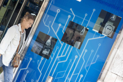 Una mujer pasa por delante la tienda Universitas Informática, mejor escaparate de la muestra 2022. SANTI OTERO
