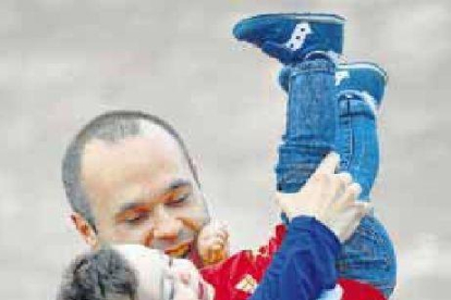 Iniesta juega con su niño en el entrenamiento de ayer.-AP