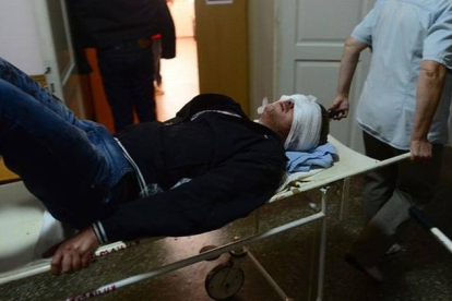 Uno de los heridos en los bombardeos de este miércoles en Donetsk llega al hospital.-Foto: AFP / JOHN MACDOUGALL