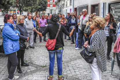 Un grupo de turistas atiende durante una ruta con guía turístico en Burgos.
