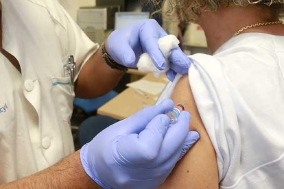 Una paciente recibe el pinchazo con la vacuna de la gripe en el centro de salud de San Agustín en Burgos capital.-RAÚL OCHOA