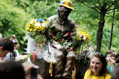 Una aficionada brasileña posa junto a la estatua que recuerda a Ayrton Senna en Imola.-REUTERS / ALESSANDRO GAROFALO