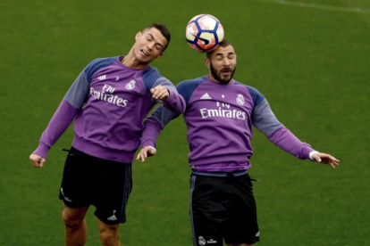 Cristiano Ronaldo y Benzema disputan el balón durante el entrenamiento de este sábado en la ciudad deportiva de Valdebebas.-EFE / JUANJO MARTÍN
