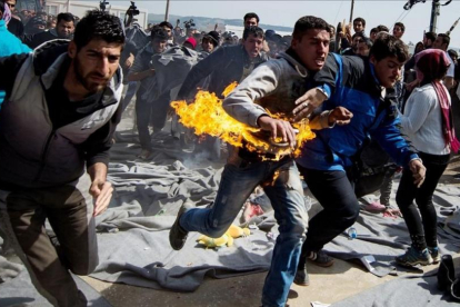Un refugiado Sirio se quema a lo bonzo en protesta por el cierre de las fronteras en el campamento de Idomeni (Grecia).-ANDREJ ISAKOVIC