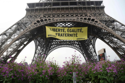 'Libertad, igualdad, fraternidad', se lee en la pancarta que Greenpeace ha colgado en la Torre Eiffel.-AFP