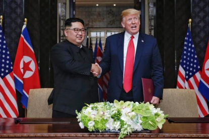 El presidente estadounidense, Donald Trump, y el líder norcoreano,  Kim Jong-un,  se estrechan la mano tras firmar una declaracion conjunta.-EFE