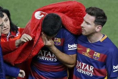 Messi consuela a Luis Suárez en el Calderón tras la lesión muscular que padeció el uruguayo.-EFE / CHEMA MOYA