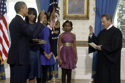 La esposa y las hijas de Obama presencian la jura de este ante John Roberts, presidente del Tribunal Supremo, este domingo en la Casa Blanca.-AP