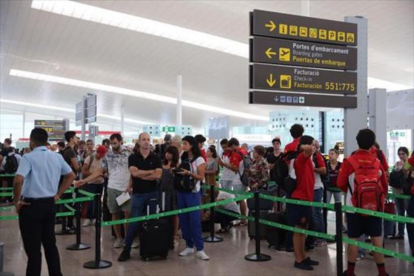 Cola de viajeros en el aeropuerto de El Prat.-ELISENDA PONS