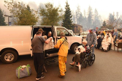 Miembros de los servicios de rescate trasladan a un grupo de personas lejos de los efectos de las llamas, en la localidad californiana de Paradise.-JOSH EDELSEN (AFP)