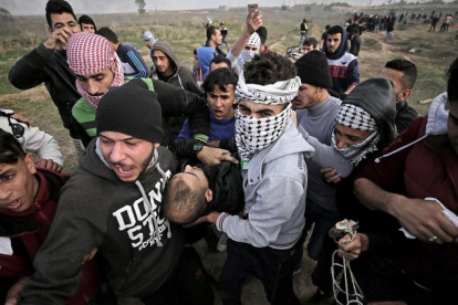 Manifestantes palestinos portan el cuerpo sin vida de Yasser Sokar, en la franja de Gaza.-EFE / MOHAMMED SABER