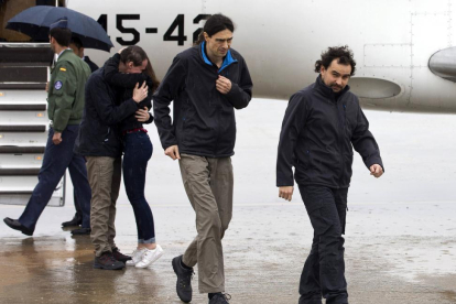 Los periodistas españoles Ángel Sastre (derecha), José Manuel López (centro) y Antonio Pampliega (abrazando a un familiar), a su llegada esta mañana a la Base Aérea de Torrejón de Ardoz, en Madrid.-EFE