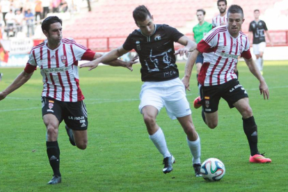 Fernando Carralero conduce el balón ante el acoso de dos jugadores del UD Logroñés.-FERNANDO DÍAZ