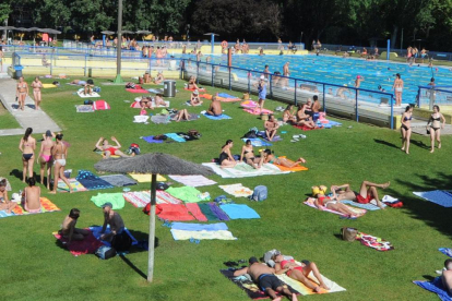 Varias personas disfrutan de las piscinas de El Plantío. ECB