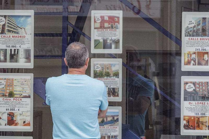 Una persona observa los anuncios de una agencia inmobiliaria.-RAÚL G. OCHOA