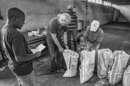 Eduardo Margareto / ICAL. Tomás Martínez, presidente de Proyecto Rubare, ayuda a preparar las mezclas de harina para hacer el pan, con Justin y Inocence