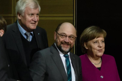 Merkel (derecha), junto a Schulz (centro) y Horst Seehofer, presidente de la CSU, durante la reunión en la sede del Partido Socialdemócrata (SPD) en Berlín, el 2 de febrero.-/ EFE / CLEMENS BILAN