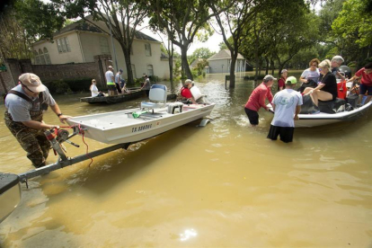 Voluntarios fueron registrados este viernes al ayudar a residentes a volver a sus casas por algunas pertenencias, tras las lluvias que provocó a su paso el huracán Harvey, en Houston (Texas, EE.UU.).-EFE