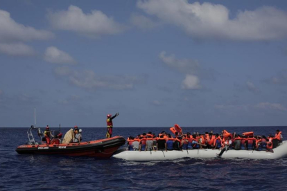 Inmigrantes esperan a ser rescatados en su atestado bote neumático por integrantes de Proactiva Open Arms, frente a las costas de Libia, el 6 de septiembre.-/ AP / BRAM JANSSEN