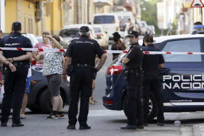 EFE / JOSÉ MANUEL VIDAL  Agentes de policía y vecinos, frente al domicilio donde un hombre ha matado a su expareja, en Sevilla.-EFE