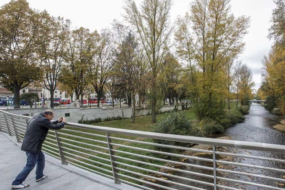 Un hombre hace una foto al río Arlanzón.-SANTI OTERO