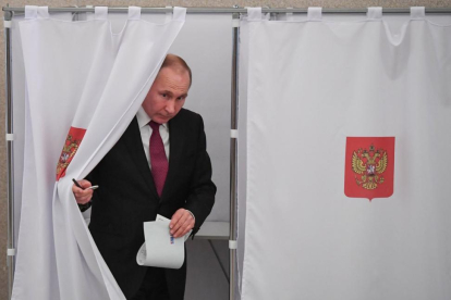 Vladimir Putin se dispone a depositar su voto en las elecciones presidenciales rusas.-/ YURI KADOBNOV POOL POOL (EFE)