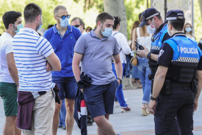 Dos policías comprobando el uso de mascarillas. ECB