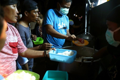 Afectados por el tsunami reciben alimentos-REUTERS / ATHIT PERAWONGMETHE