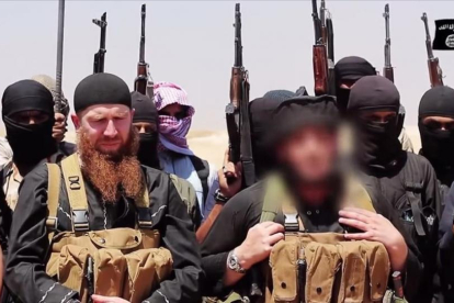 Imagen difundida por el EI en la que aparece Adnani (en primer plano, a la derecha) con el rostro difuminado para esconder su identidad, en un lugar indeterminado, en junio del 2014.-AFP