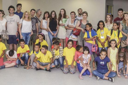 Familias y niños participantes en el programa Vacaciones en paz compartieron la primera foto en la iglesia de los Dominicos antes de partir cada uno a sus casas.-Santi Otero