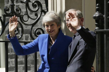 Theresa May junto a su marido Philip May saludan tras abandonar Downing Street.-AP / TIM IRELAND