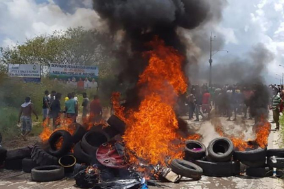 Habitantes de la ciudad brasileña de Pacaraima, en la frontera con Venezuela, incendian neumáticos y pertenencias de inmigrantes venezolanos durante los disturbios registrados el 18 de agosto del 2018.-AFP / ISAC DANTES